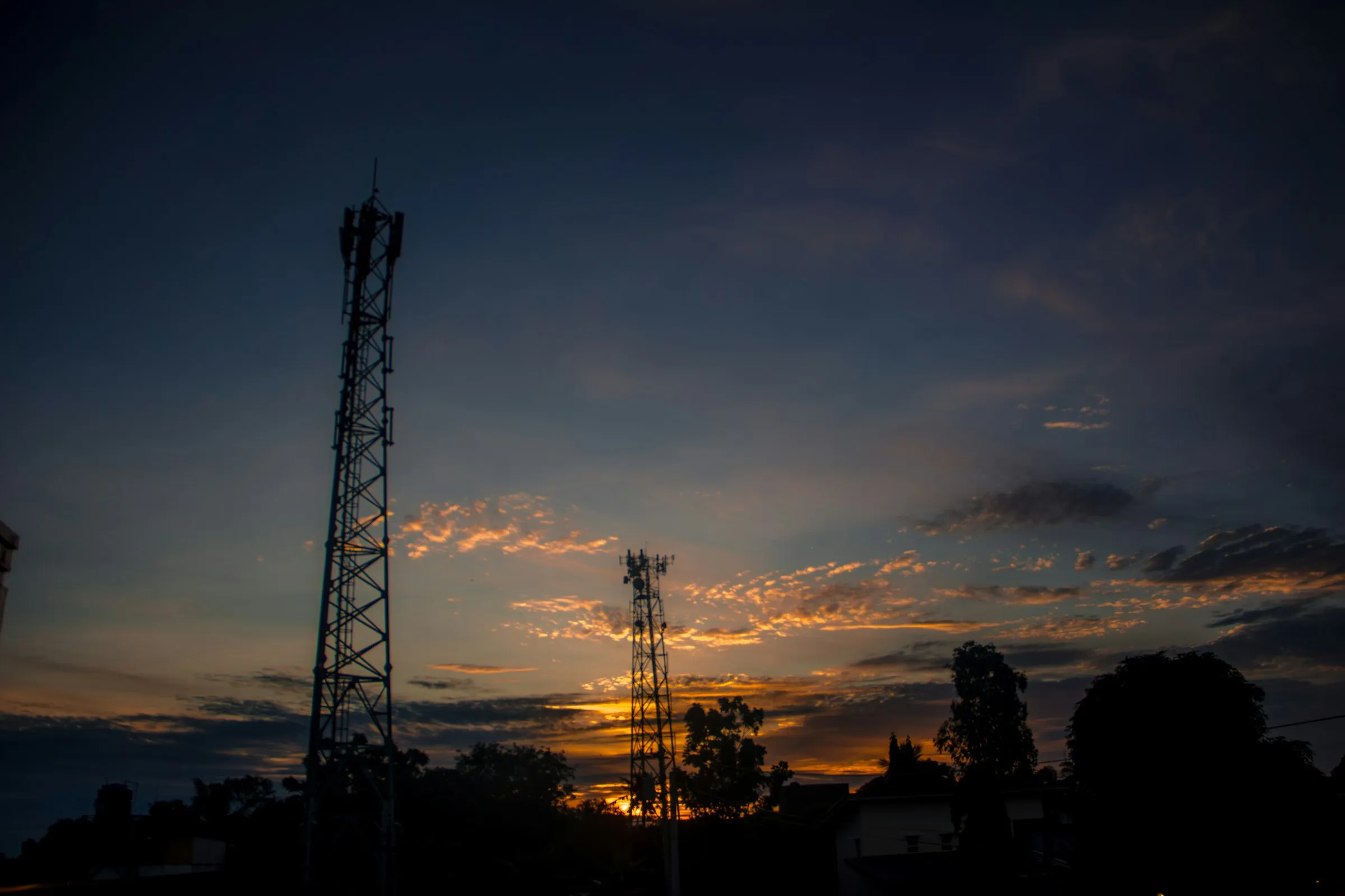 Torres de telecomunicaciones recortadas contra el cielo al atardecer